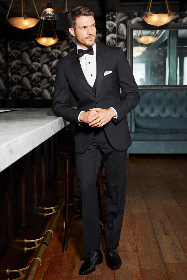 Classic black three-piece tuxedo with black bow tie and white pocket square, available to rent from Cindy and crew at Party Pizazz in Bullhead City, AZ