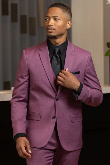 Man wearing a purple formal suit with a black shirt and tie