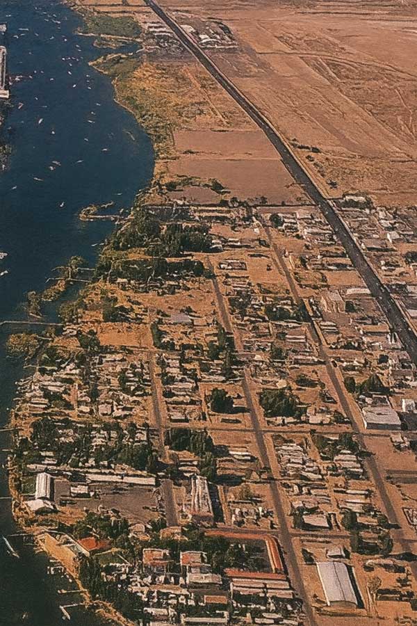 Historic aerial view of Bullhead City, Arizona (circa 1990s) with the Colorado River on the left, Highway 95 slicing north–south, and a grid of desert streets and buildings below
