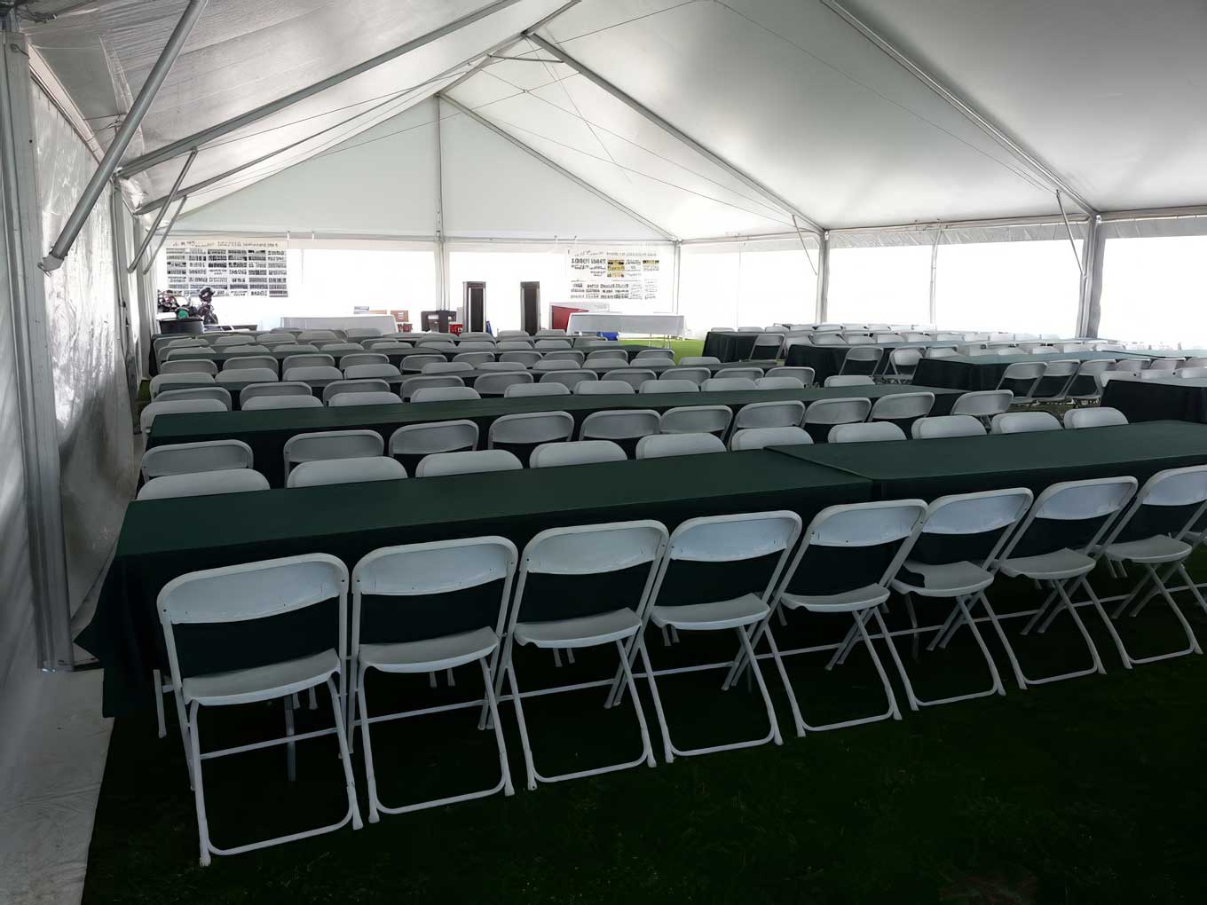 Inside an event tent with tables and chairs set by Party Pizazz